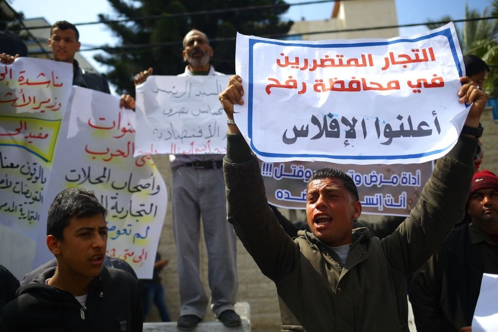 أصحاب مصانع فلسطينية تضررت بفعل العدوان الإسرائيلي على قطاع غزّة عام 2014، يتظاهرون أمام مقر الأمم المتحدة للمطالبة بإعادة بناء مصانعهم المدمرة. مارس 2017. (محمد عابد/AFP).