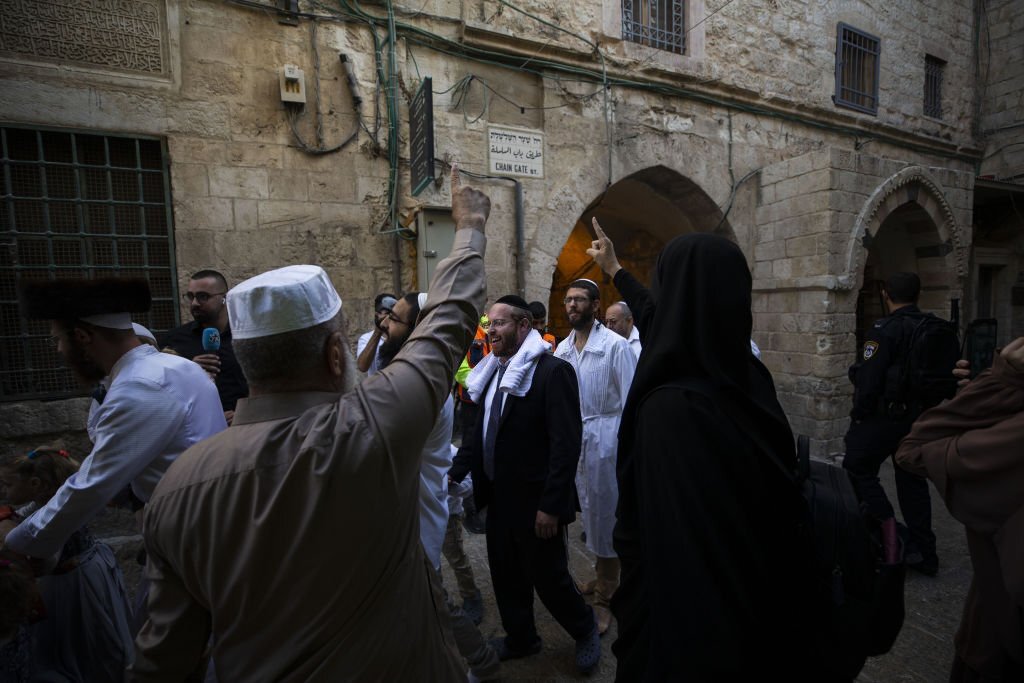 فلسطينيون مُنعوا من دخول الأقصى يهتفون في وجه المستوطنين المقتحمين وهم في طريق خروجهم من الأقصى، بالقرب من باب السلسلة، غربي المسجد، وذلك بالتزامن مع عيد رأس السنة العبرية، أيلول 2022. (وكالة الأناضول).
