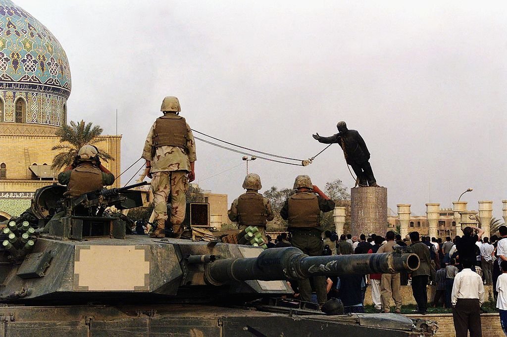 بغداد، العراق، 9 نيسان 2003، قوات أميركية تُزيل تمثالاً للرئيس العراقي السابق صدام حسين من دوار الفردوس بعد احتلالها المدينة. (Getty Images).